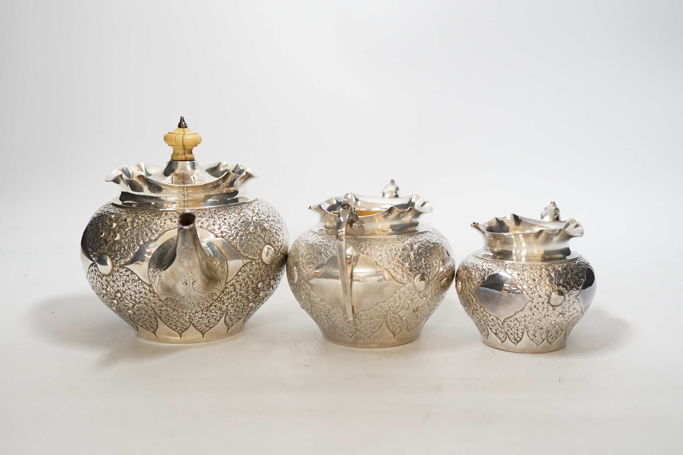 A Victorian embossed silver three piece bachelors tea set, Charles Edwards, London, 1880, gross weight 17.9oz., CITES Submission reference WAD4FJG4